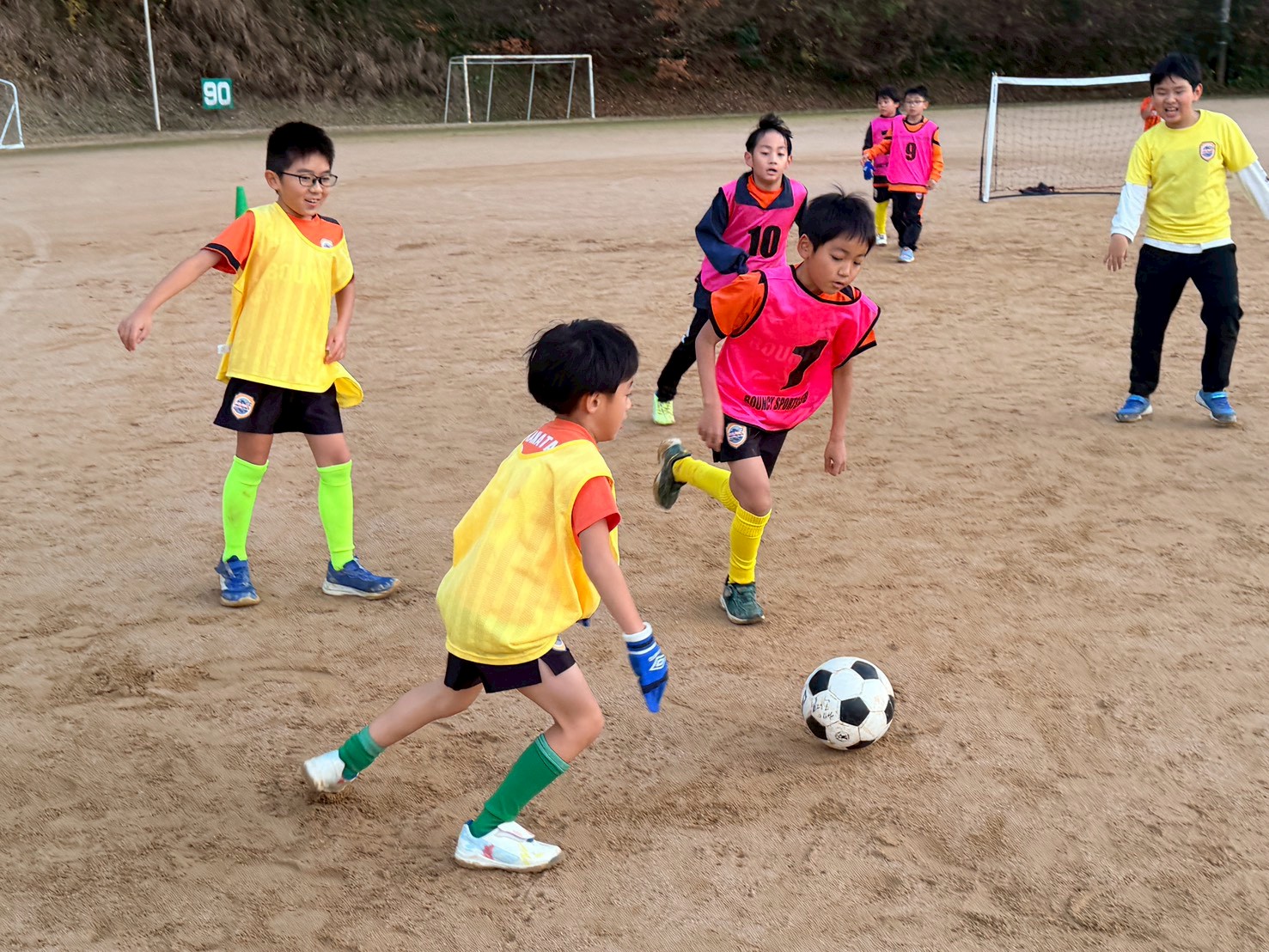 屋外でサッカー指導を行う様子